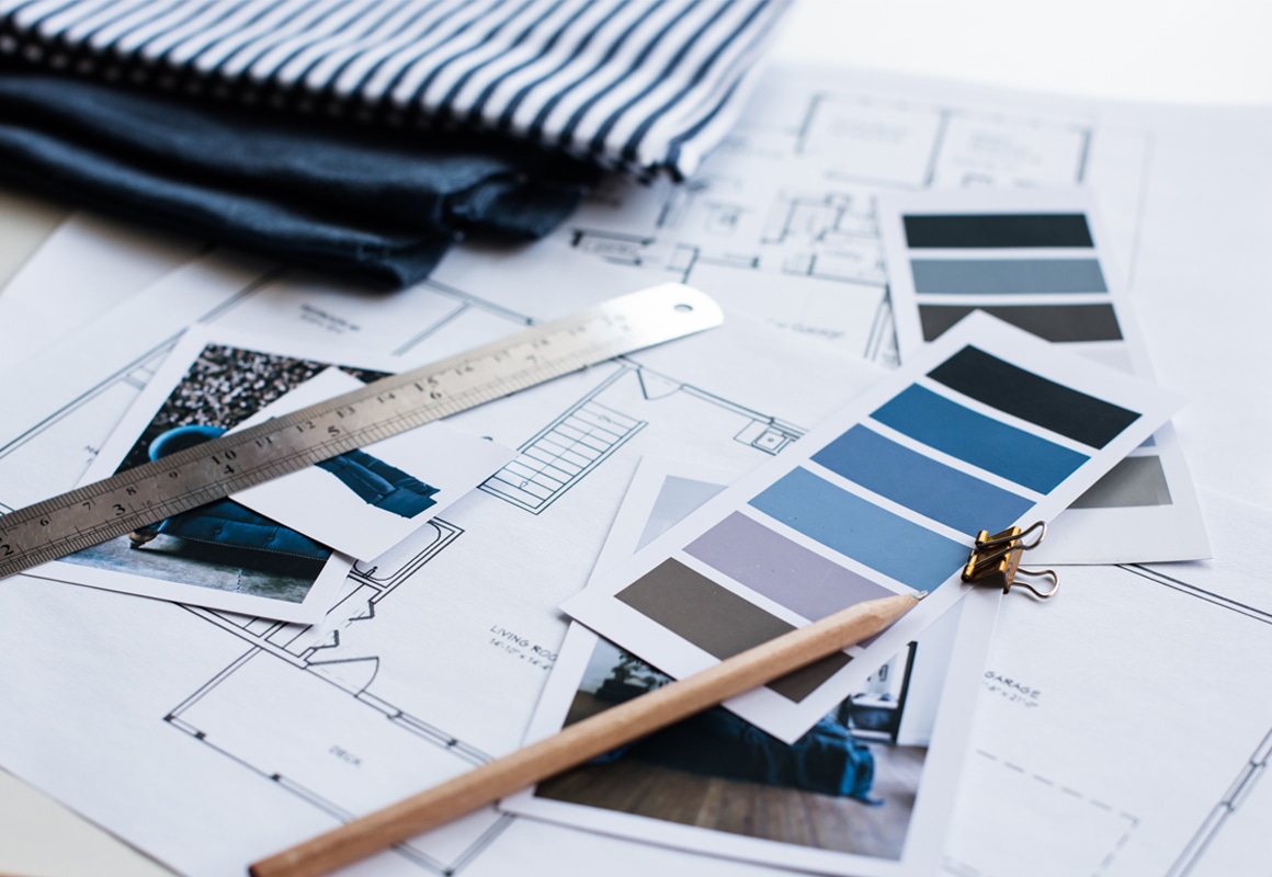 House plans, paint samples, ruler and pencil laid on a table