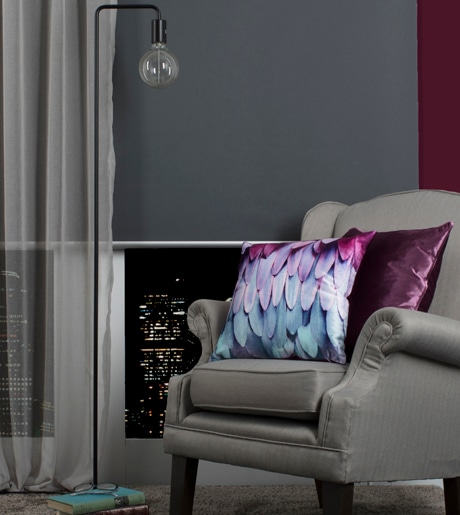 grey sheer curtains and dark grey blockout roller blind in luxury sitting room on red walls